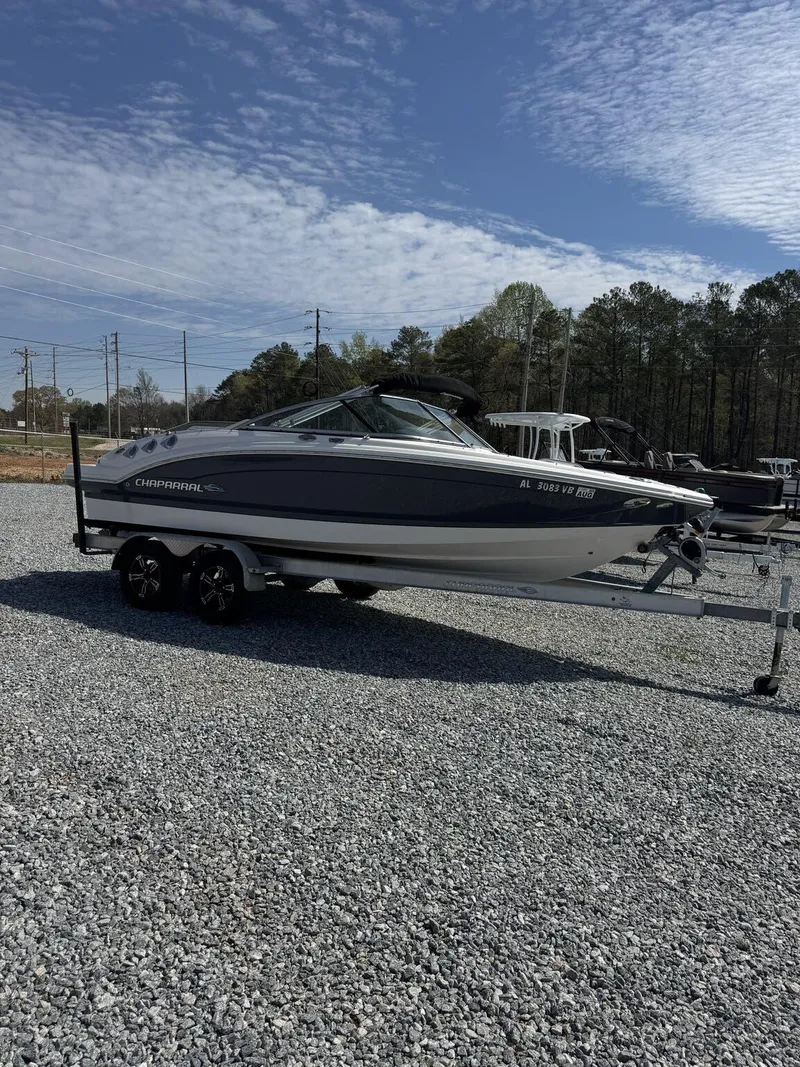 Slide: The Image of 2014 Chaparral 206 SSi boat on trailer, parked on gravel lot under blue sky. - 6