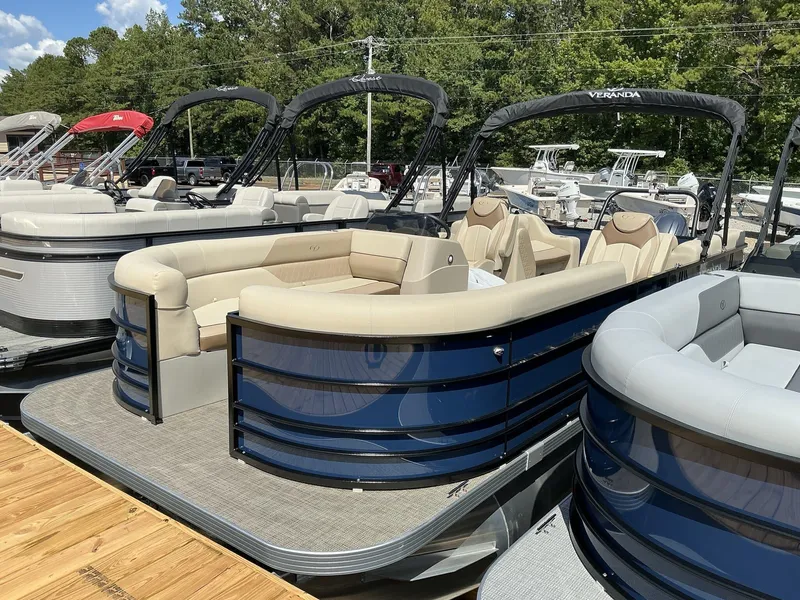 Slide: The Image of 2025 Veranda Vista View Series pontoon boat with beige seating, docked under sunny skies. - 3