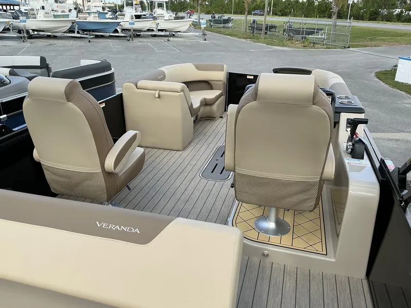 Slide: The Image of 2025 Veranda Relax Series VR22VLC pontoon boat interior with beige seating and helm. - 10