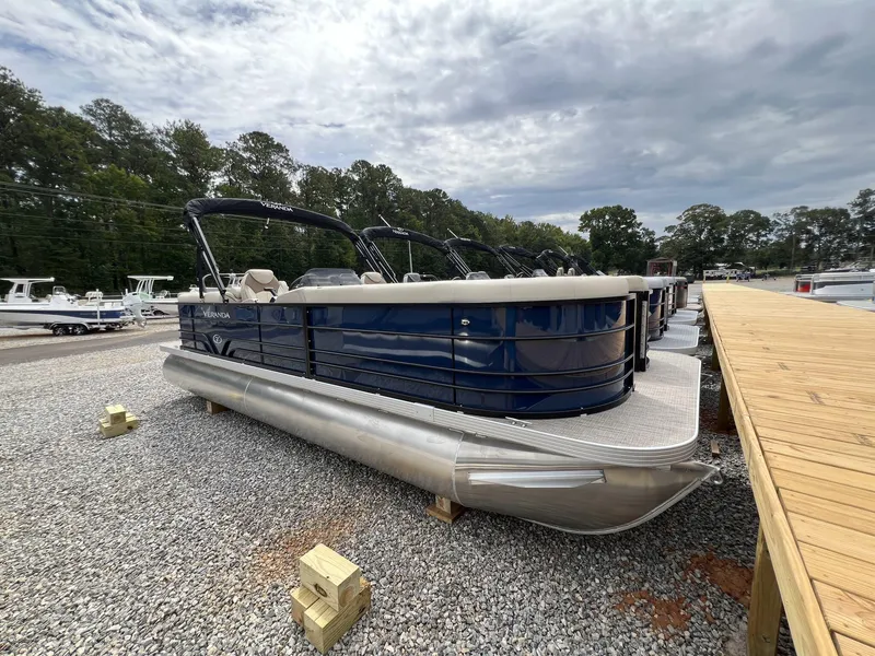 Slide: The Image of 2025 Veranda Vista View Series pontoon boat on gravel near dock. - 2