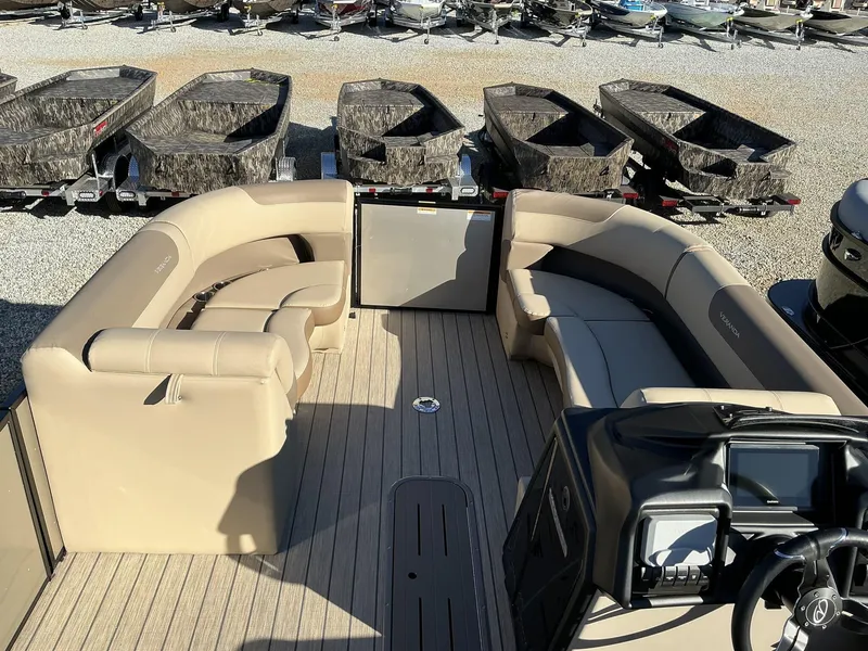 Slide: The Image of 2025 Veranda Relax Series 22RC pontoon boat interior with beige seating and control panel. - 13