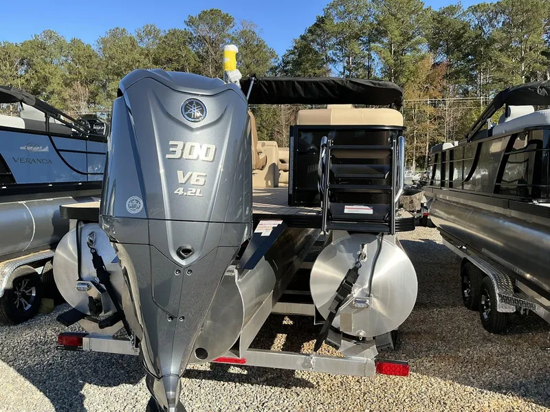 Slide: The Image of 2025 Veranda Relax Series 22RC pontoon boat with Yamaha 300 V6 engine, parked outdoors. - 22