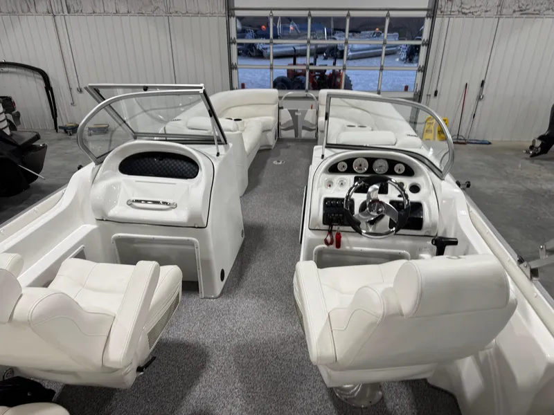 Slide: The Image of Interior of 2015 PlayCraft 2600 Sport Toon boat with white seating and dashboard. - 10