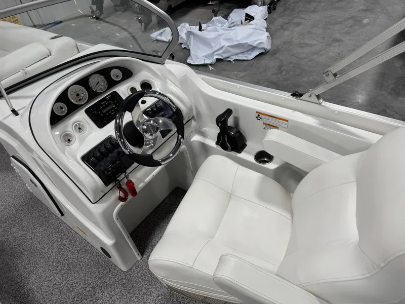 Slide: The Image of 2015 PlayCraft 2600 Sport Toon boat interior with steering wheel and white seating. - 16