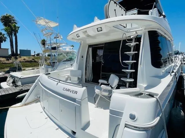 Slide: The Image of 2000 Carver 530 Voyager Pilothouse yacht docked, featuring spacious deck and modern design. - 3
