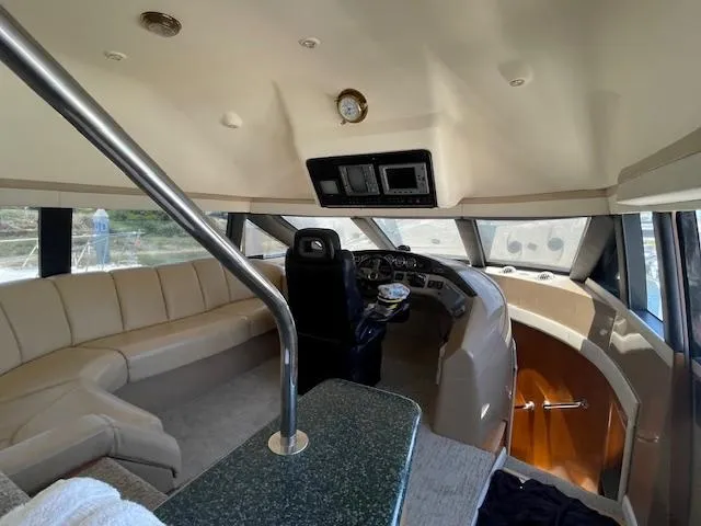 Slide: The Image of 2000 Carver 530 Voyager Pilothouse interior with helm, seating, and panoramic windows. - 32