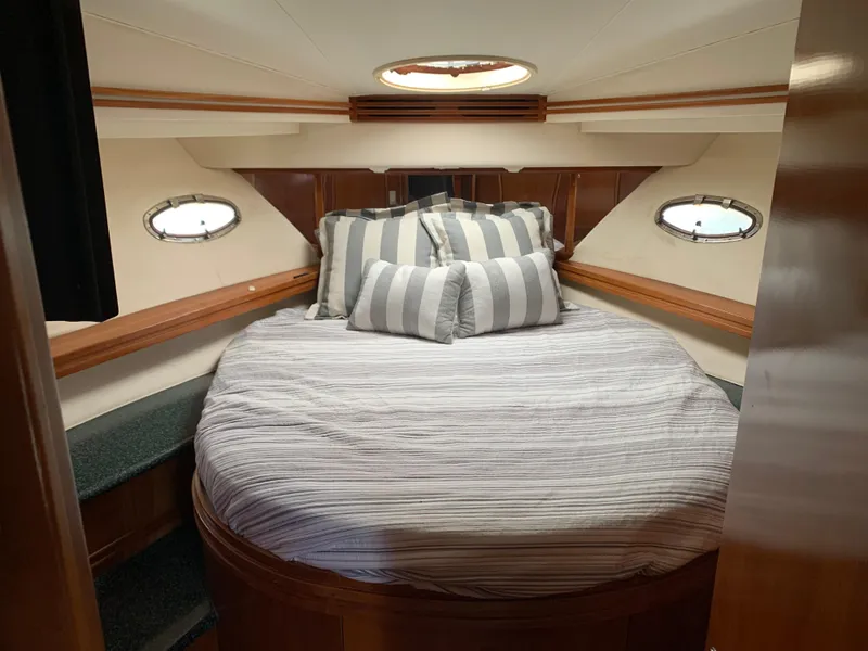 Slide: The Image of Luxurious bedroom in 2000 Carver 530 Voyager Pilothouse yacht with striped bedding. - 43