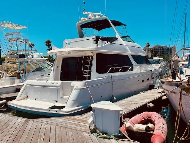 Slide: The Image of 2000 Carver 530 Voyager Pilothouse yacht docked at marina under clear blue sky. - 6