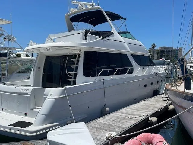 Slide: The Image of 2000 Carver 530 Voyager Pilothouse yacht docked at marina under clear blue sky. - 8