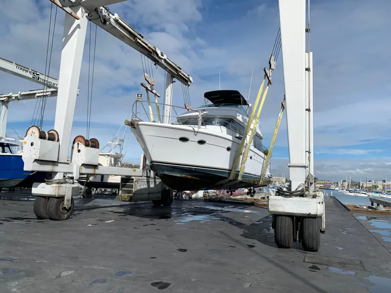 Slide: The Image of 2000 Carver 530 Voyager Pilothouse yacht lifted by crane at marina. - 9