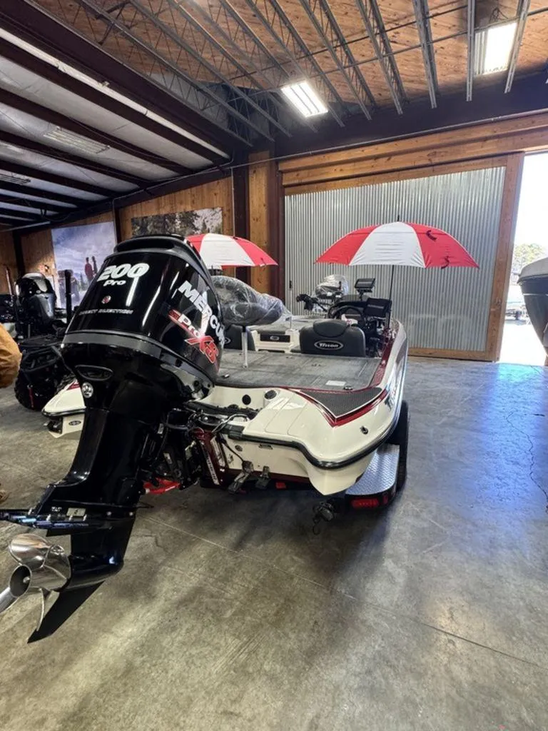 Slide: The Image of 2016 Triton 18 TrX boat with Mercury engine in a showroom setting. - 10