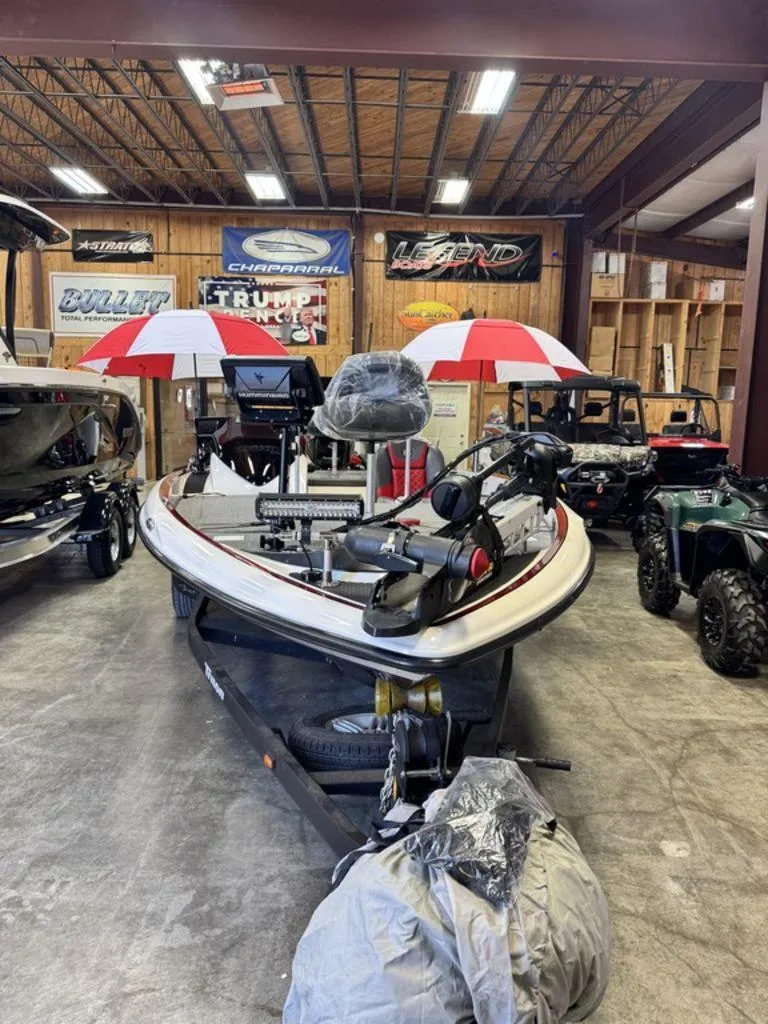 Slide: The Image of 2016 Triton 18 TrX boat in showroom with red and white umbrellas. - 15