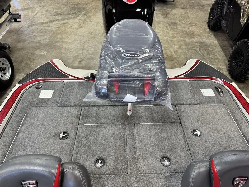 Slide: The Image of 2016 Triton 18 TrX boat interior with covered seat and carpeted deck. - 19