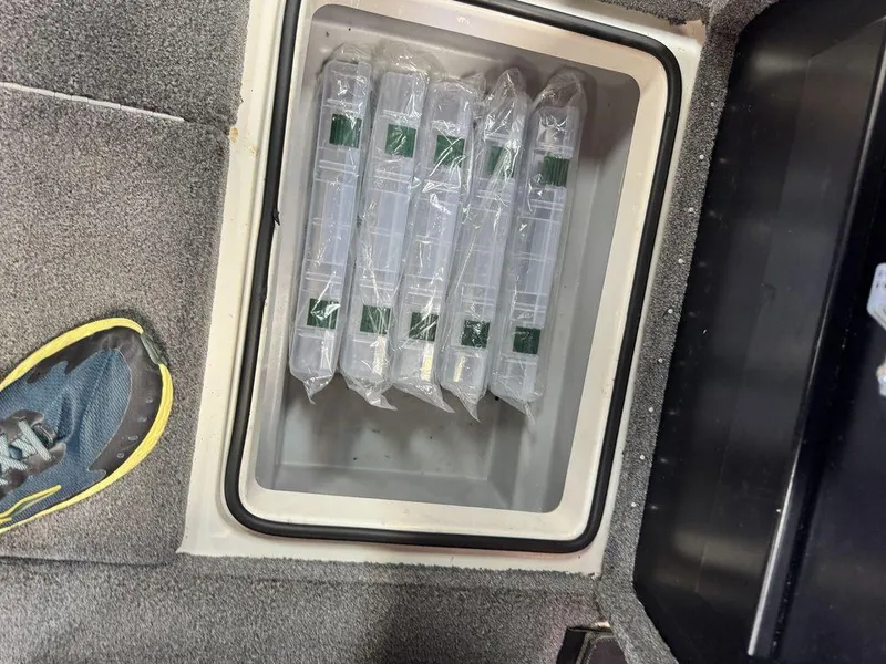 Slide: The Image of Storage compartment in 2016 Triton 18 TrX boat with organized plastic containers. - 25