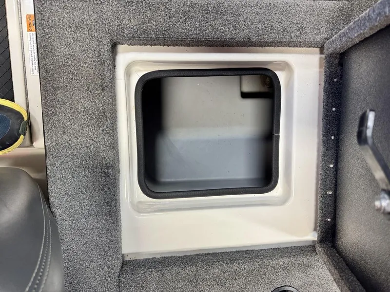 Slide: The Image of Storage compartment in a 2016 Triton 18 TrX boat, featuring carpeted interior. - 29