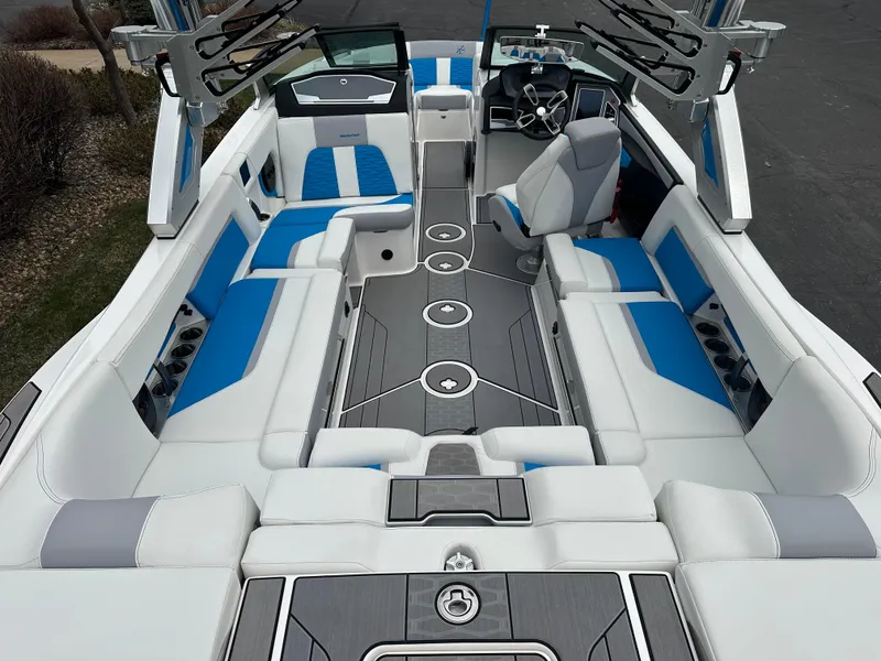 Slide: The Image of 2023 MasterCraft X24 boat interior with blue and white seating, sleek design, and modern dashboard. - 10