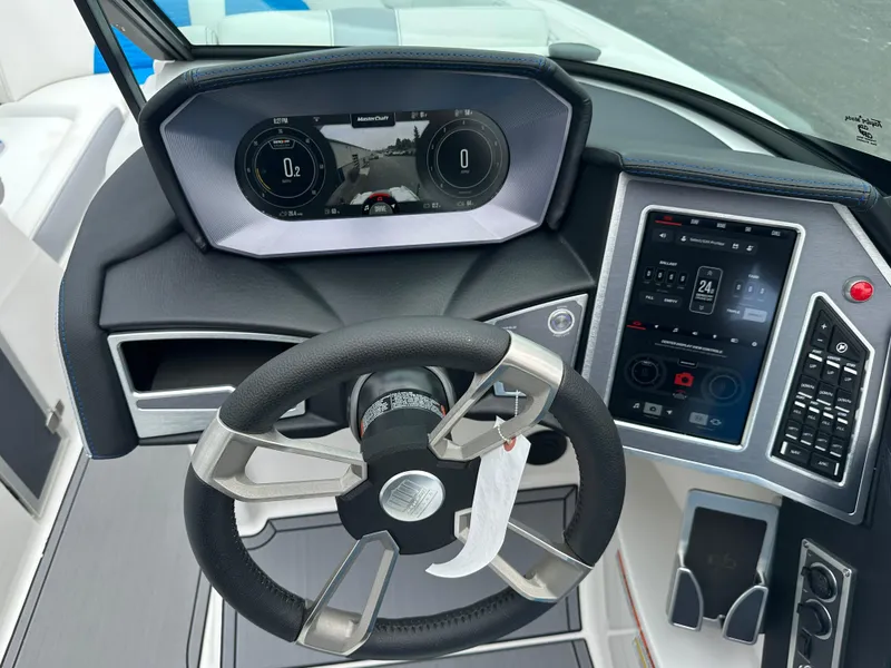 Slide: The Image of 2023 MasterCraft X24 boat dashboard with advanced digital controls and steering wheel. - 13