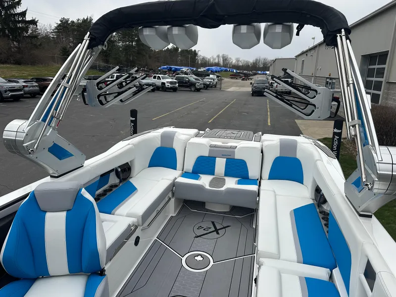 Slide: The Image of 2023 MasterCraft X24 boat interior with blue and white seating, advanced audio system, and sleek design. - 18