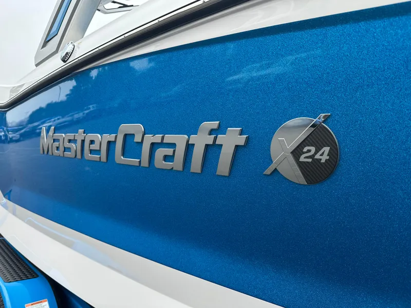 Slide: The Image of 2023 MasterCraft X24 boat with blue exterior and logo detail. - 3