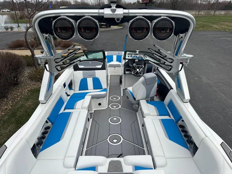 Slide: The Image of 2023 MasterCraft X24 boat interior with blue and white seating, advanced sound system, and sleek design. - 8