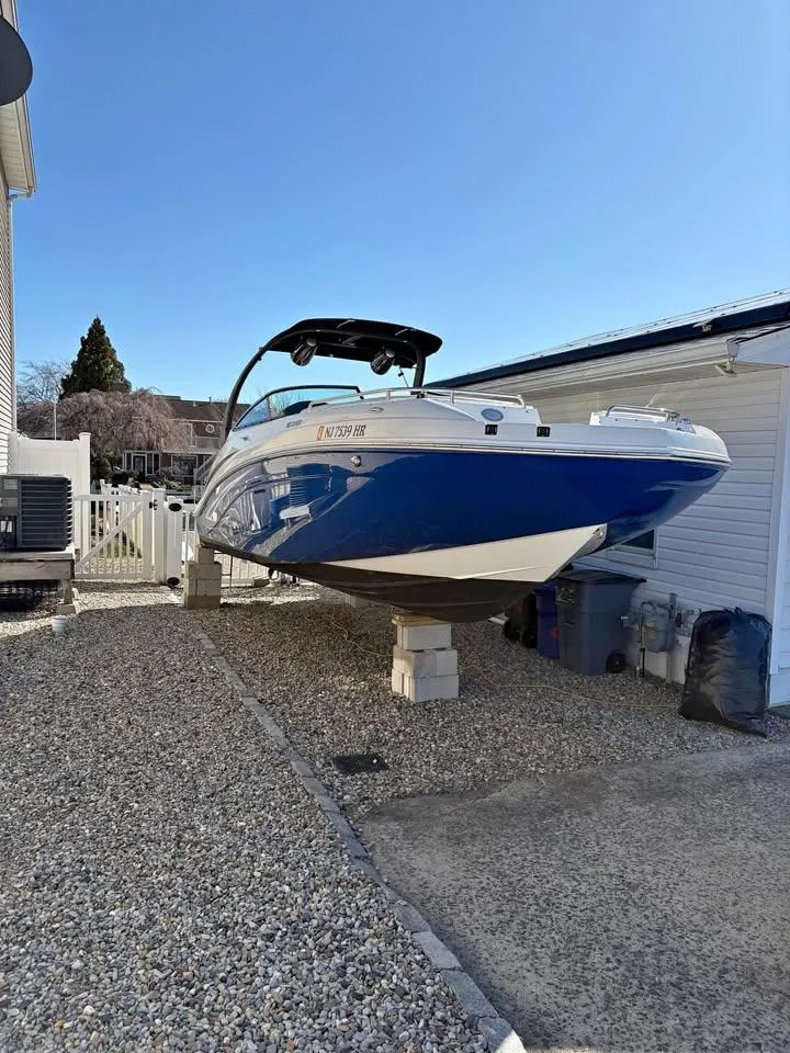 Slide: The Image of 2022 Hurricane SunDeck 2486 OB boat on dry dock, blue and white exterior. - 0