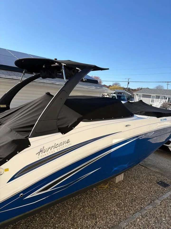 Slide: The Image of 2022 Hurricane SunDeck 2486 OB boat with blue and white exterior, covered and docked. - 1