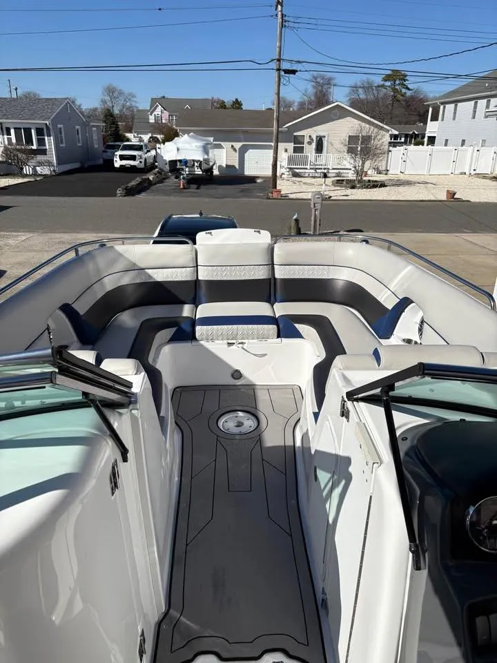 Slide: The Image of 2022 Hurricane SunDeck 2486 OB boat with spacious seating, docked in a residential area. - 6