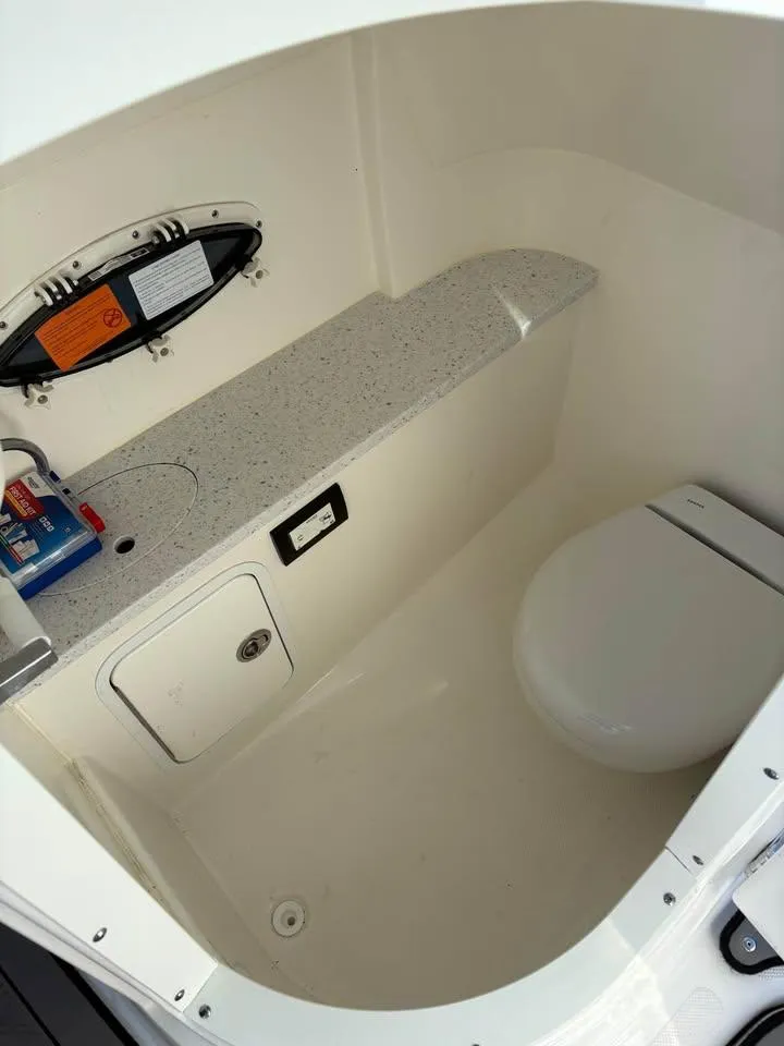 Slide: The Image of 2022 Hurricane SunDeck 2486 OB boat interior with compact bathroom and toilet. - 8