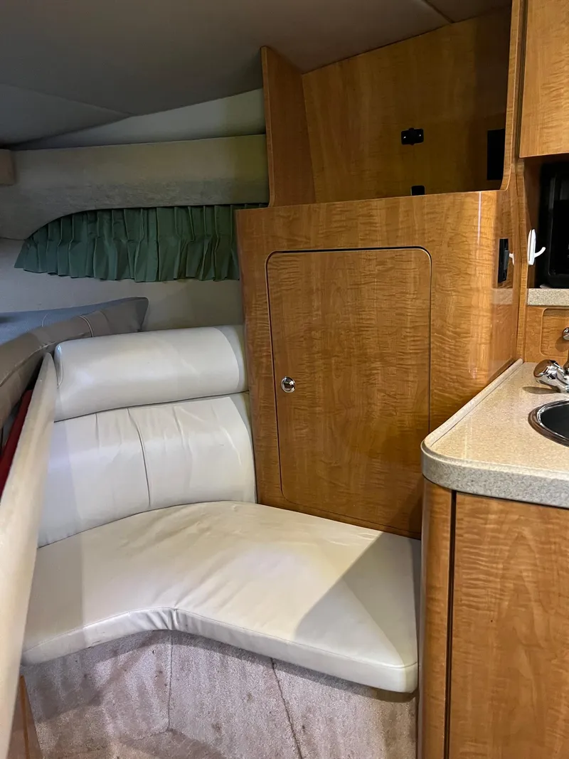 Slide: The Image of Interior of 2003 Regal Commodore 3260 boat with wood cabinetry and white seating. - 12