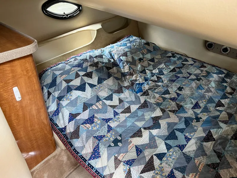Slide: The Image of Cozy cabin interior of 2003 Regal Commodore 3260 with patterned quilt bedding. - 17