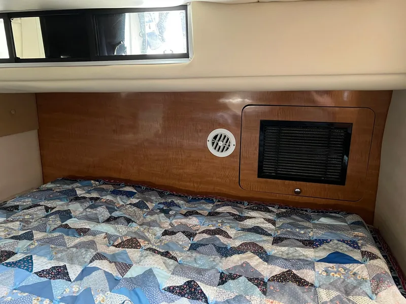 Slide: The Image of Interior cabin of 2003 Regal Commodore 3260 with quilted bedding and wood paneling. - 18
