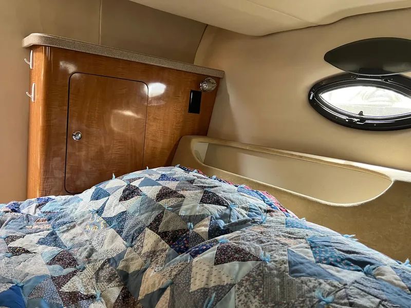 Slide: The Image of Cabin interior of 2003 Regal Commodore 3260 with quilted bedding and wooden cabinetry. - 19