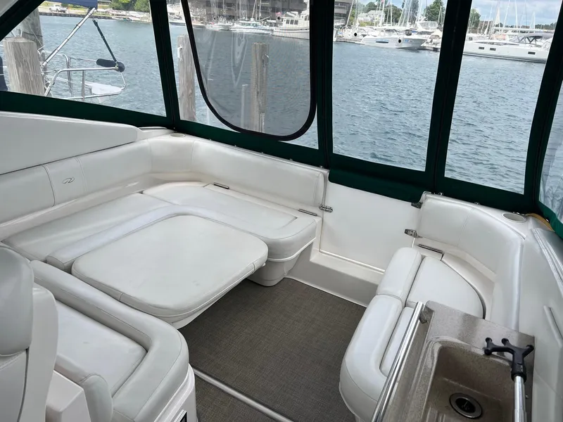 Slide: The Image of 2003 Regal Commodore 3260 boat interior with white seating and lake view. - 2