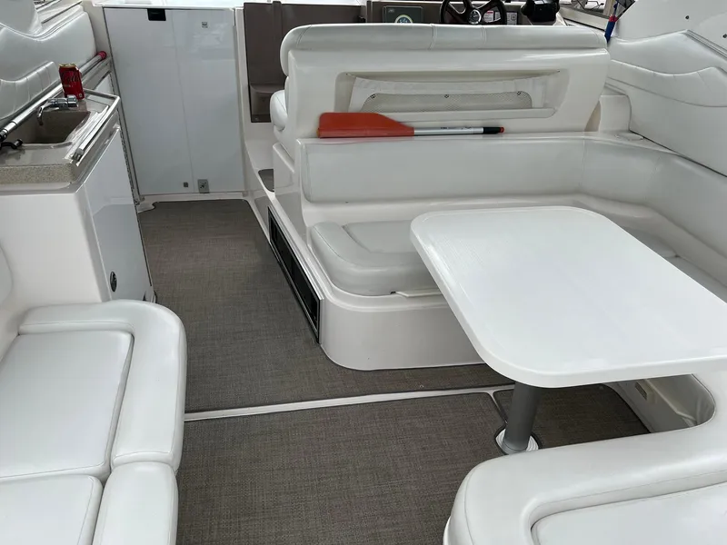 Slide: The Image of 2003 Regal Commodore 3260 interior with white seating and table, showcasing luxury boat design. - 3