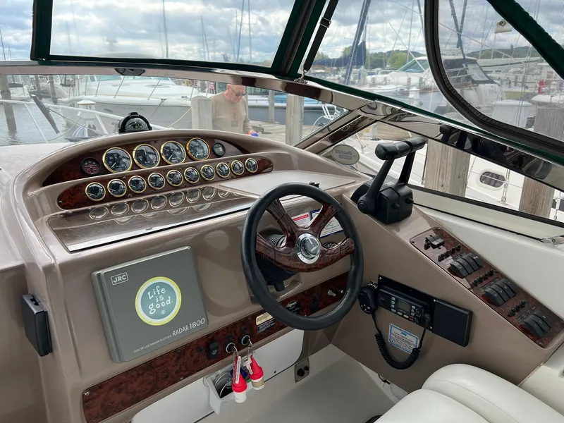 Slide: The Image of 2003 Regal Commodore 3260 boat dashboard with steering wheel and control panel at marina. - 6