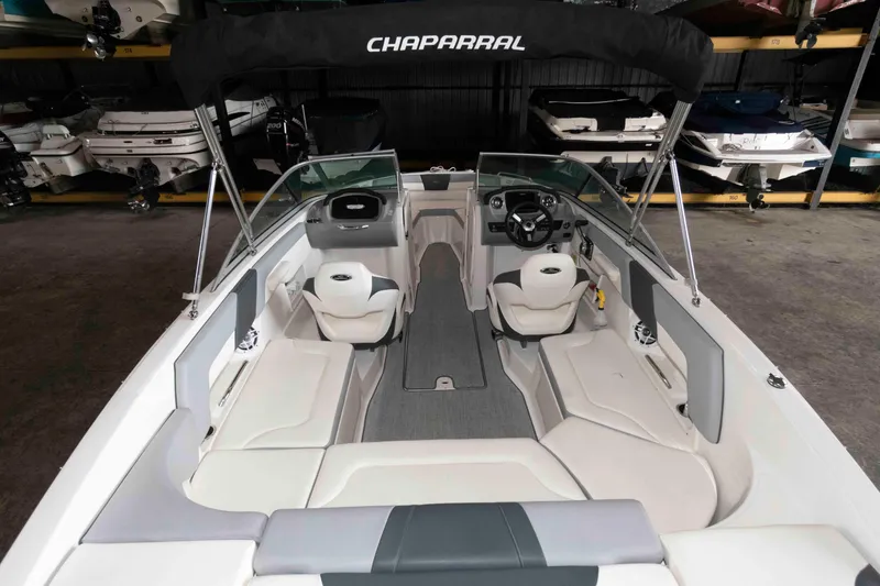 Slide: The Image of 2022 Chaparral 23 SSi boat interior with seating and steering wheel in storage facility. - 4