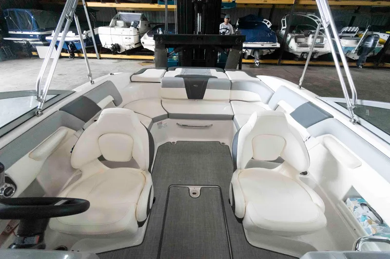 Slide: The Image of 2022 Chaparral 23 SSi boat interior with white seating and modern design in storage facility. - 7