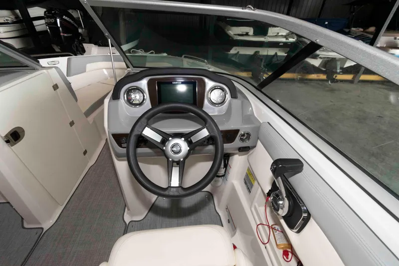Slide: The Image of 2022 Chaparral 23 SSi boat interior with steering wheel and dashboard controls. - 9