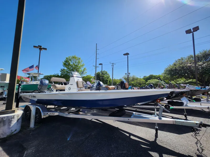 Slide: The Image of 2025 Avid 23FSX boat on trailer under clear blue sky. - 1