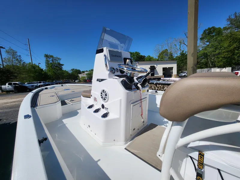 Slide: The Image of 2025 Avid 23FSX boat interior with steering console and seating, under clear blue sky. - 6