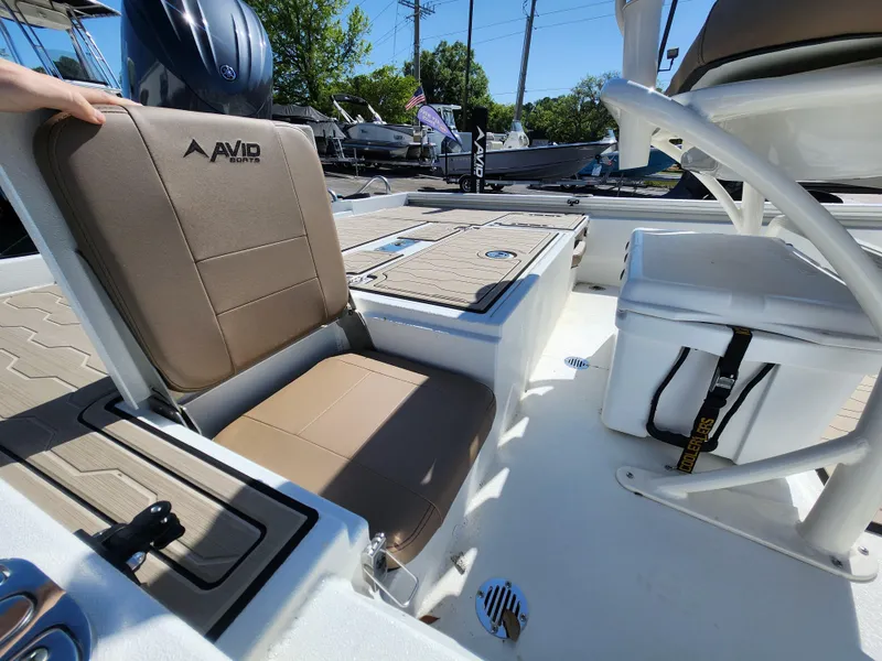 Slide: The Image of 2025 Avid 23FSX boat interior with tan seating and storage compartments. - 9