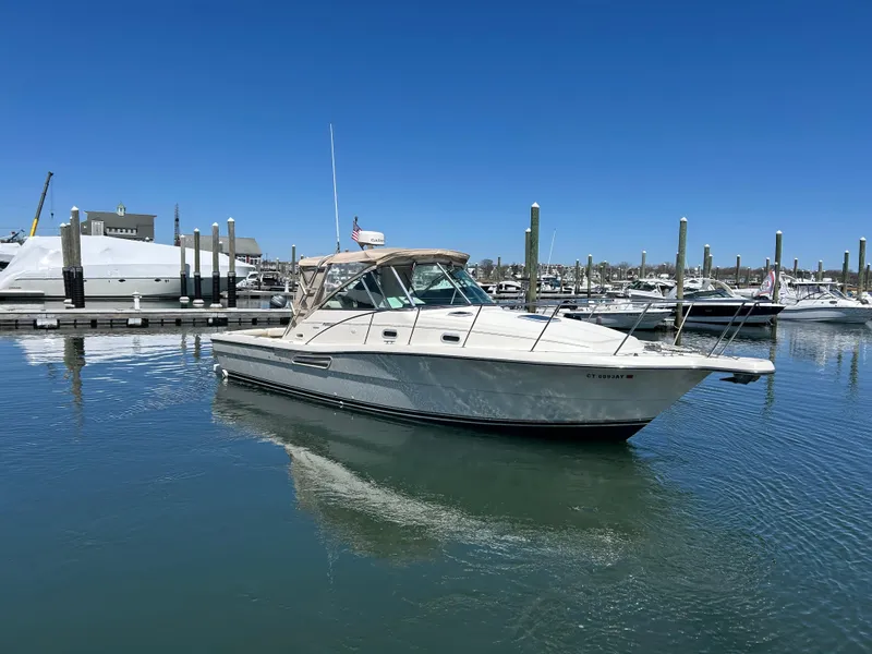 Slide: The Image of 2001 Pursuit 3000 Express boat docked in a marina under clear blue skies. - 0