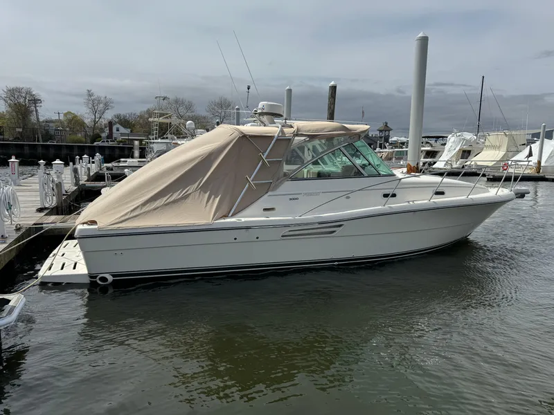 Slide: The Image of 2001 Pursuit 3000 Express boat docked in a marina, covered with a beige canopy. - 1