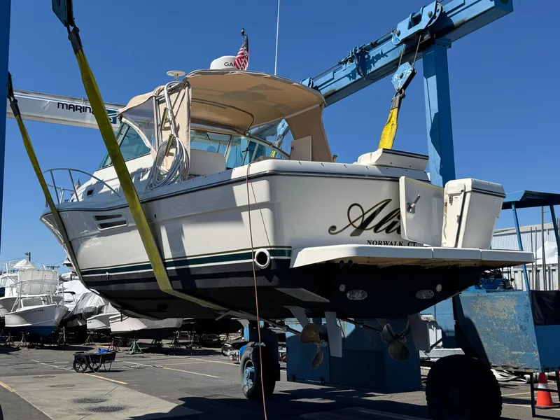 Slide: The Image of 2001 Pursuit 3000 Express boat lifted in marina, ready for maintenance. - 12