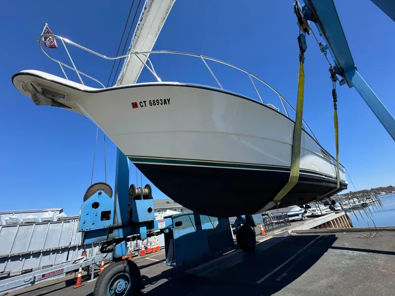 Slide: The Image of 2001 Pursuit 3000 Express boat lifted by crane at marina. - 15