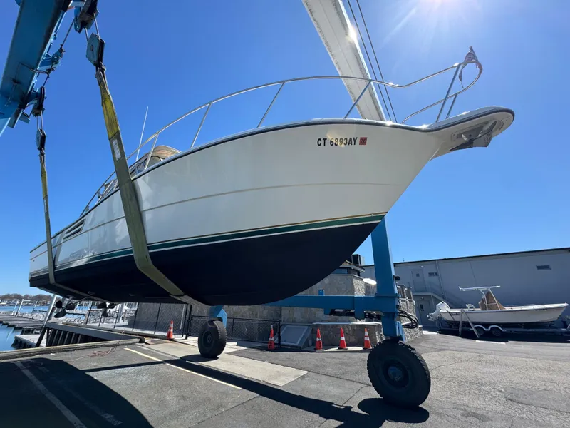 Slide: The Image of 2001 Pursuit 3000 Express boat lifted at marina under clear blue sky. - 17