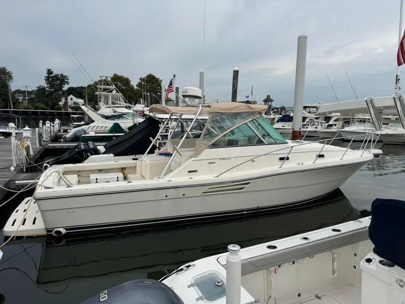 Slide: The Image of 2001 Pursuit 3000 Express boat docked at a marina, side view. - 19