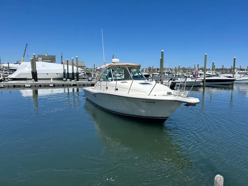 Slide: The Image of 2001 Pursuit 3000 Express boat docked in a marina under clear blue skies. - 2