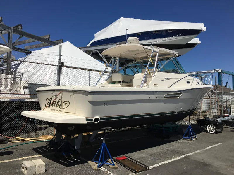 Slide: The Image of 2001 Pursuit 3000 Express boat on stands in a marina storage area. - 23