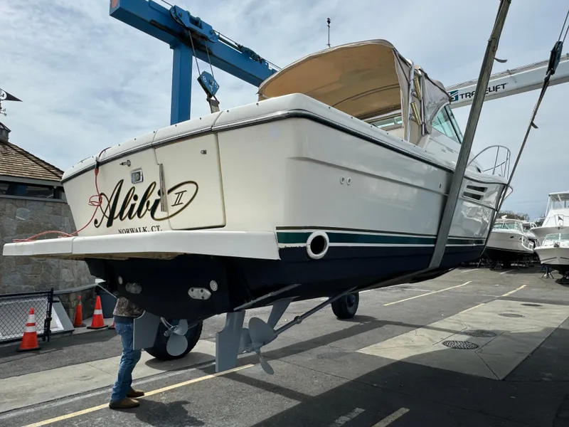 Slide: The Image of 2001 Pursuit 3000 Express boat being lifted at a marina. - 24
